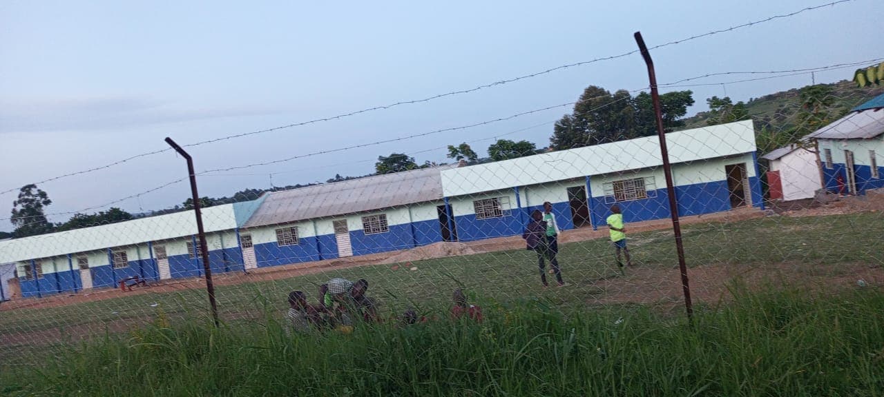 People working on the school grounds beside the classroom block