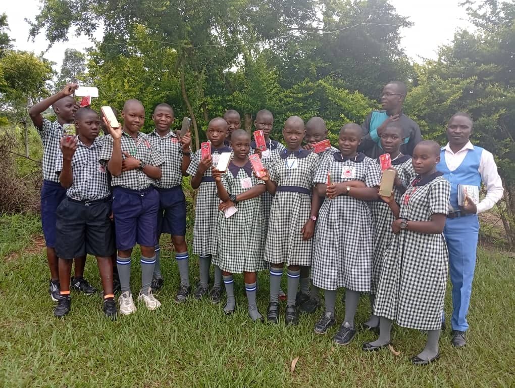 Pupils holding up scholastic materials received during a donation day at St. Mary's