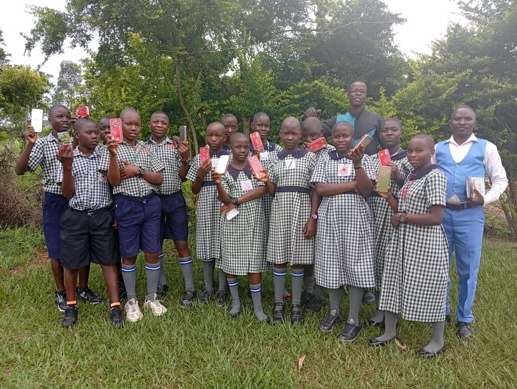 Pupils holding up scholastic materials received during a donation day at St. Mary's