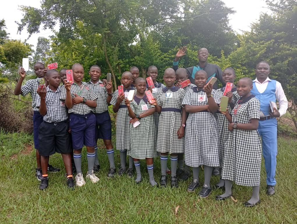 Pupils holding up scholastic materials received during a donation day at St. Mary's