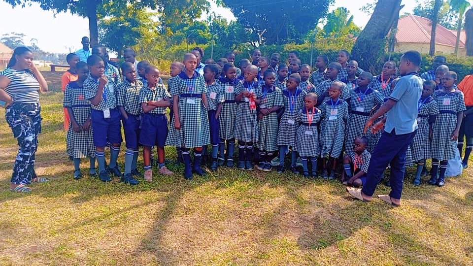 Pupils gathered on the school grounds under a large tree