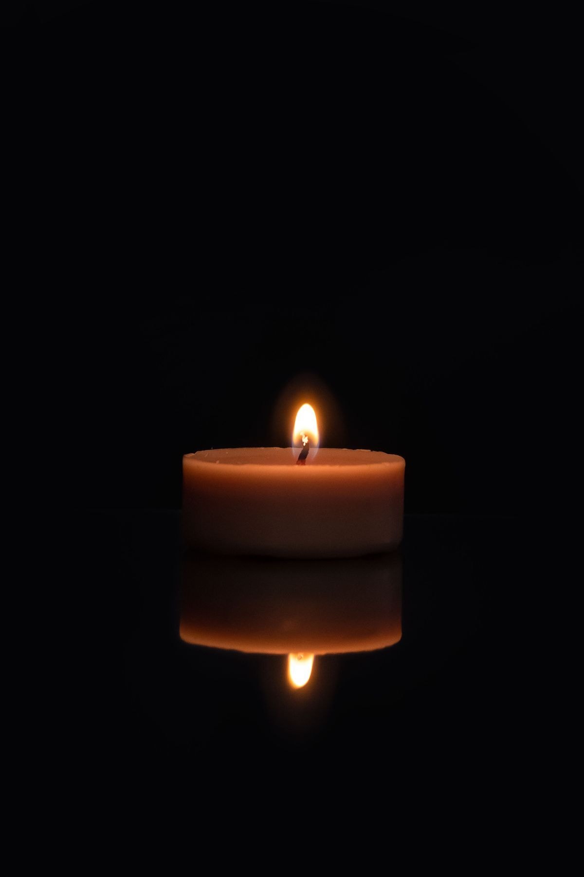 A lit candle, representing the chapel planned for St. Mary's